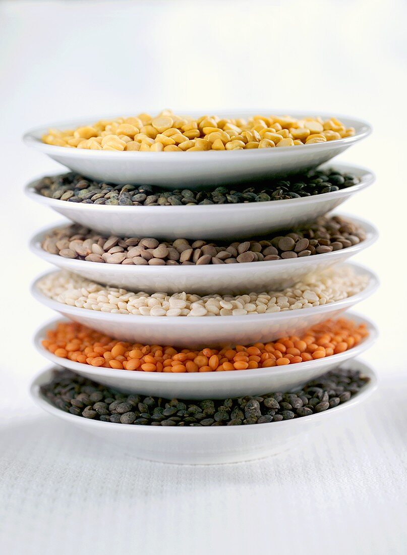 Various types of lentils on stacked plates