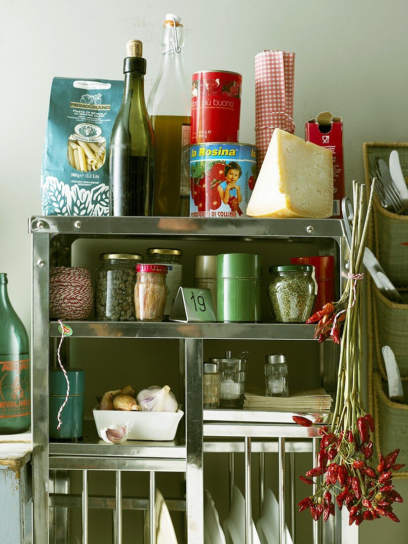 Various foods and utensils on kitchen shelf unit
