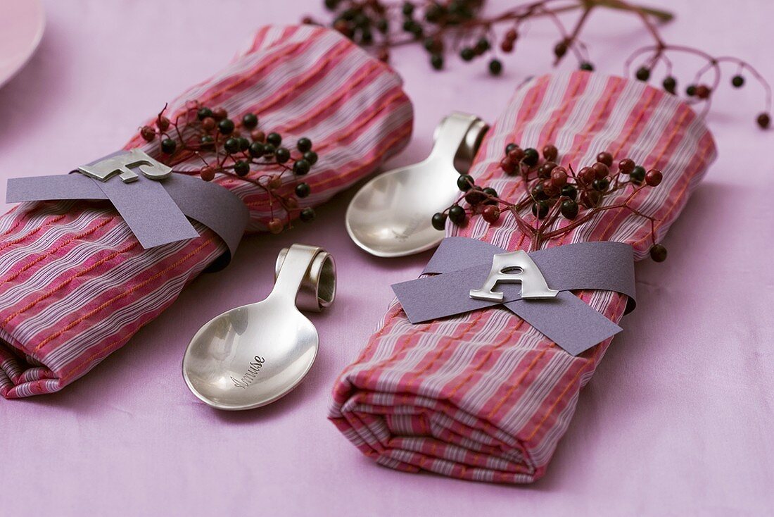 Two fabric napkins with napkin rings and elderberries