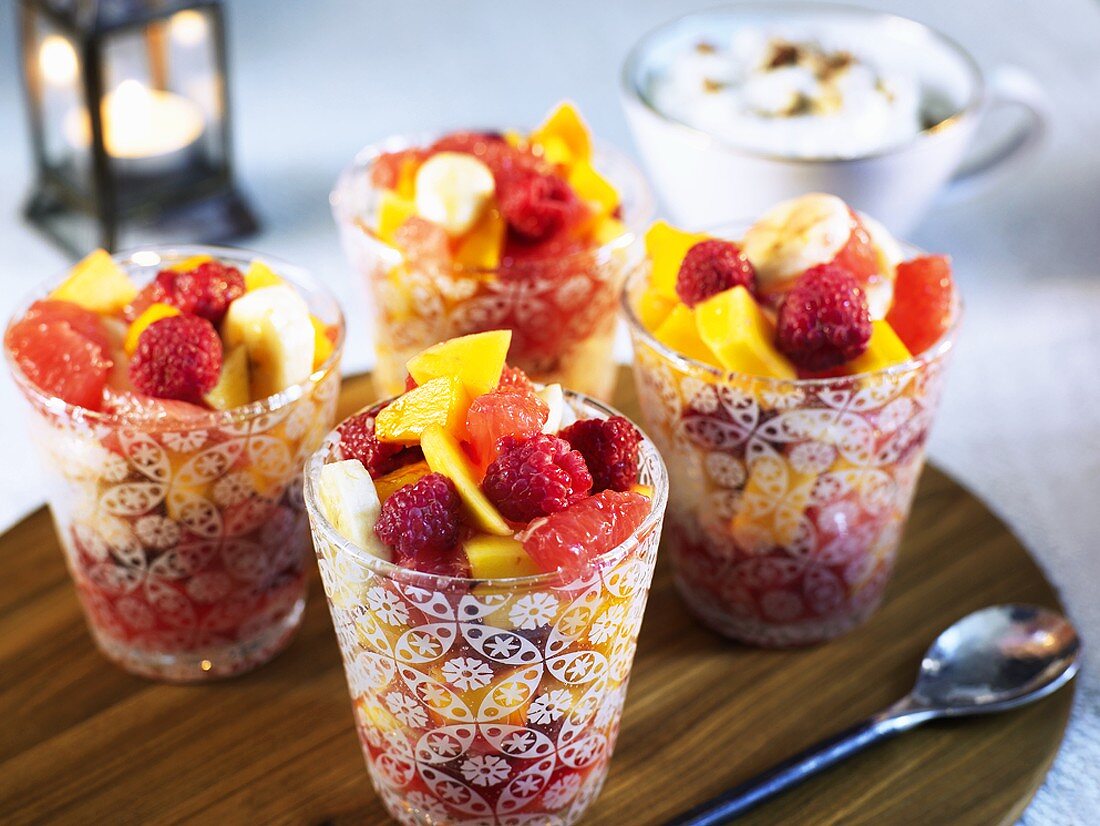 Exotic fruit salad with berries in four glasses