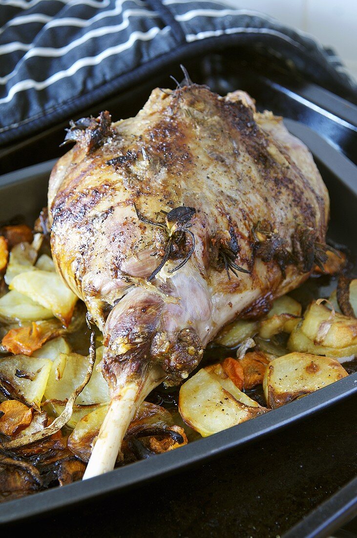 Leg of lamb studded with rosemary & garlic in roasting tin
