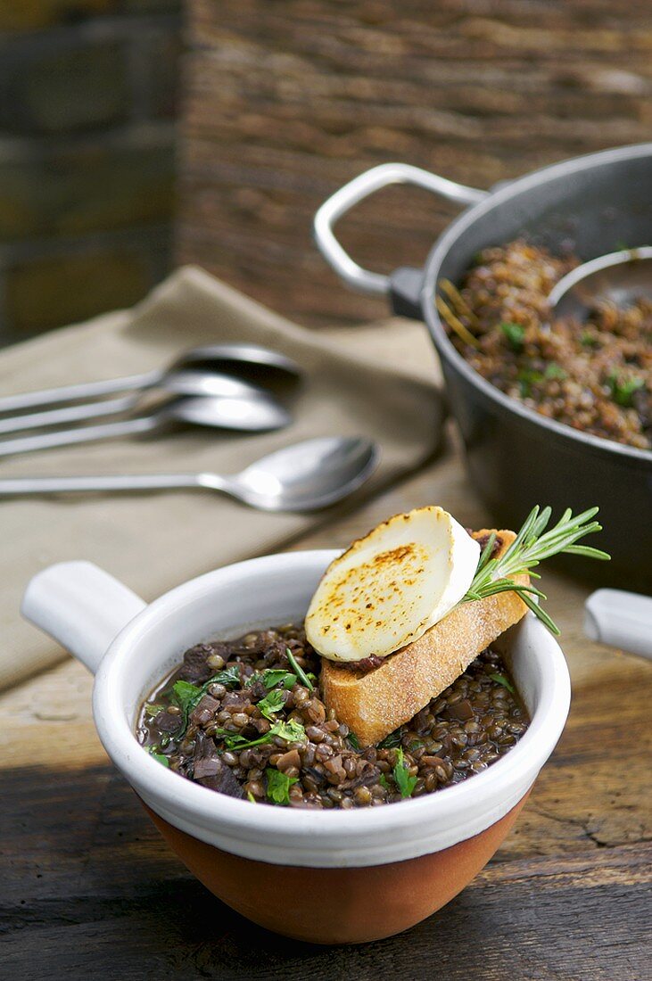 Baked goat cheese baguette on red wine lentils