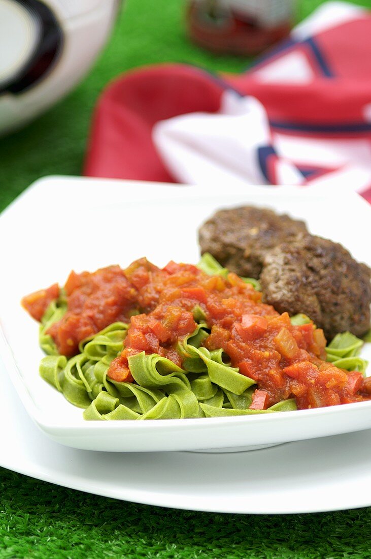 Green ribbon pasta with burgers and tomato sauce