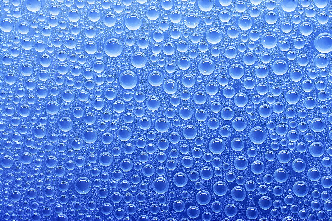 Wassertropfen auf Glasscheibe mit blauem Hintergrund