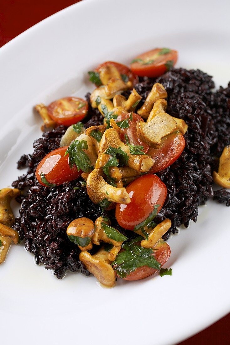 Risotto von schwarzem Reis mit Pfifferlingen und Tomaten