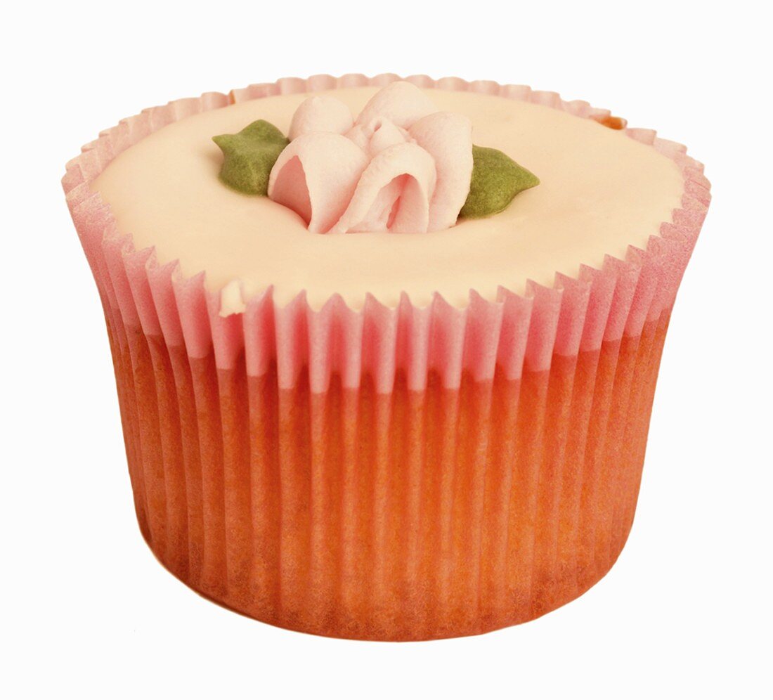 A cupcake with pink icing and sugar flower
