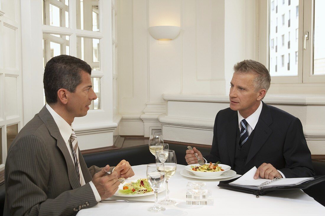 Two men having a meeting over a meal in a restaurant