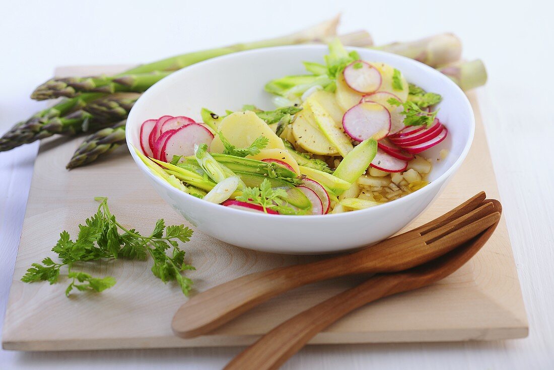 Potato salad with raw green asparagus and radishes