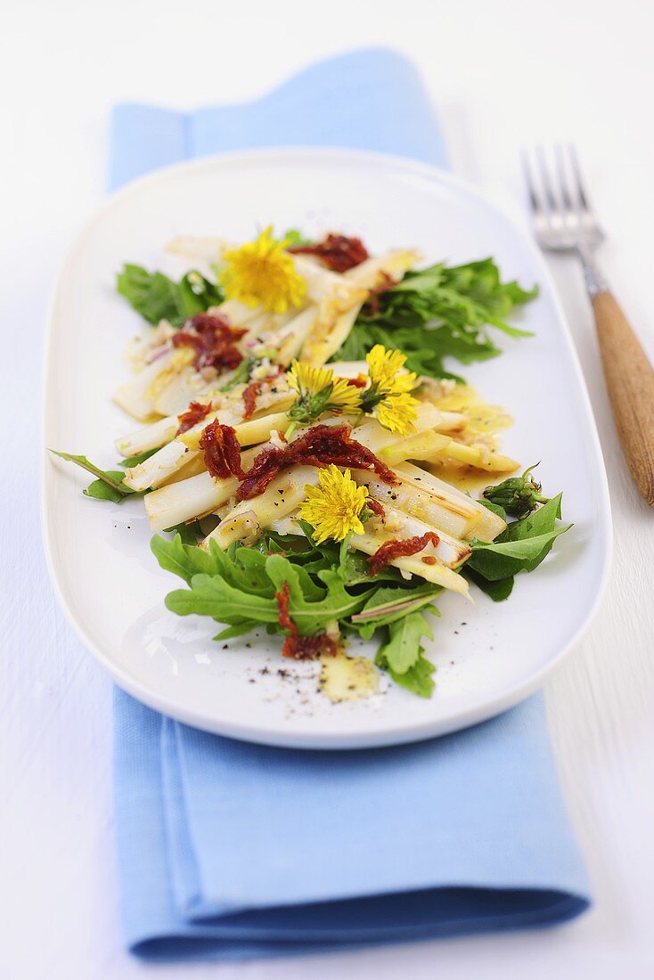 Gebratener weisser Spargel mit getrockneten Tomaten auf Rucola