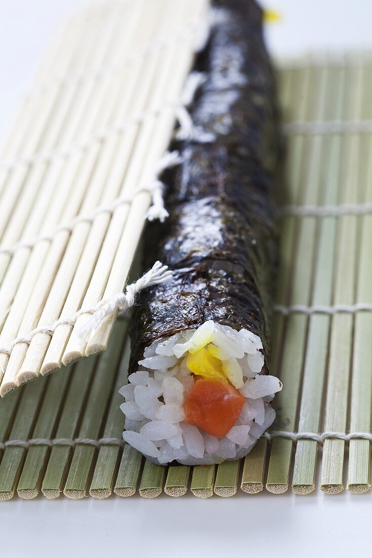 Sushi mit Lachs und Ingwer werden gerollt