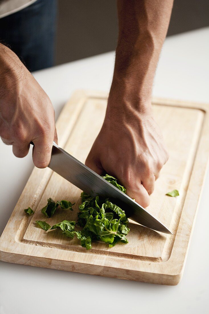 Chiffonade zubereiten: aufgerollte Salatblätter in Streifen schneiden