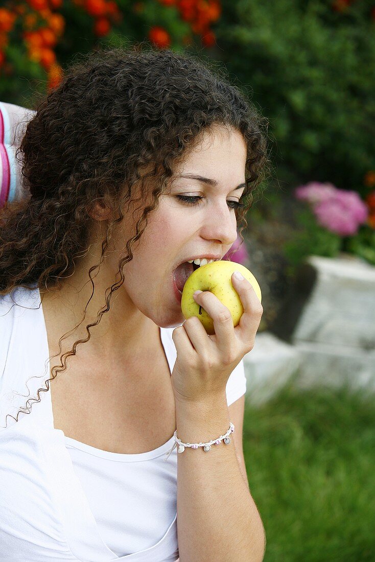 A young woman eating an apple