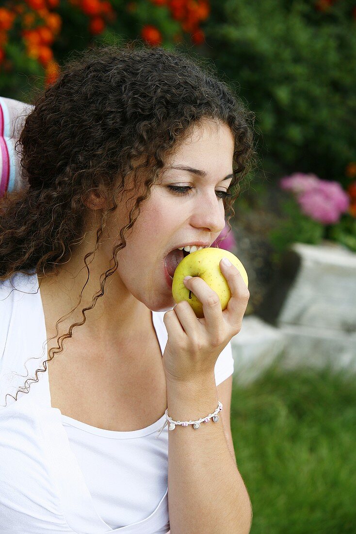 Junge Frau isst einen Apfel