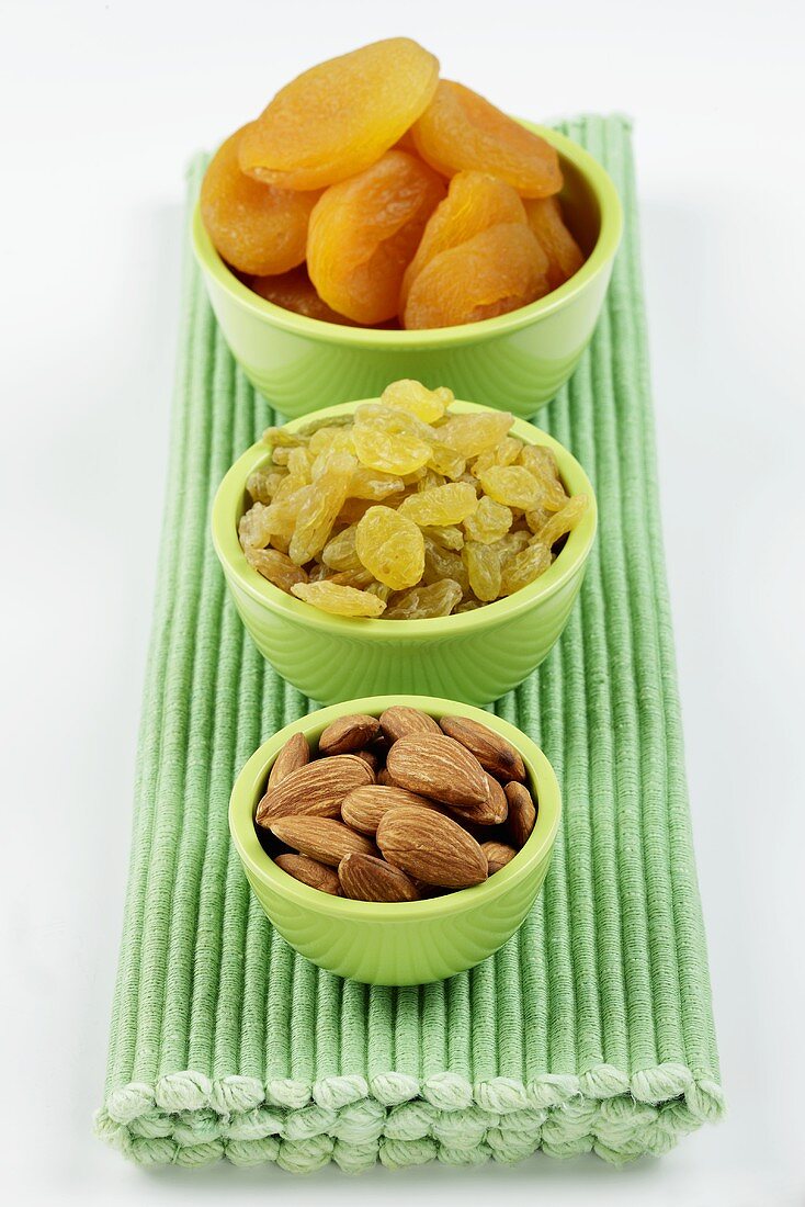 Dried apricots, sultanas and almonds in small bowls