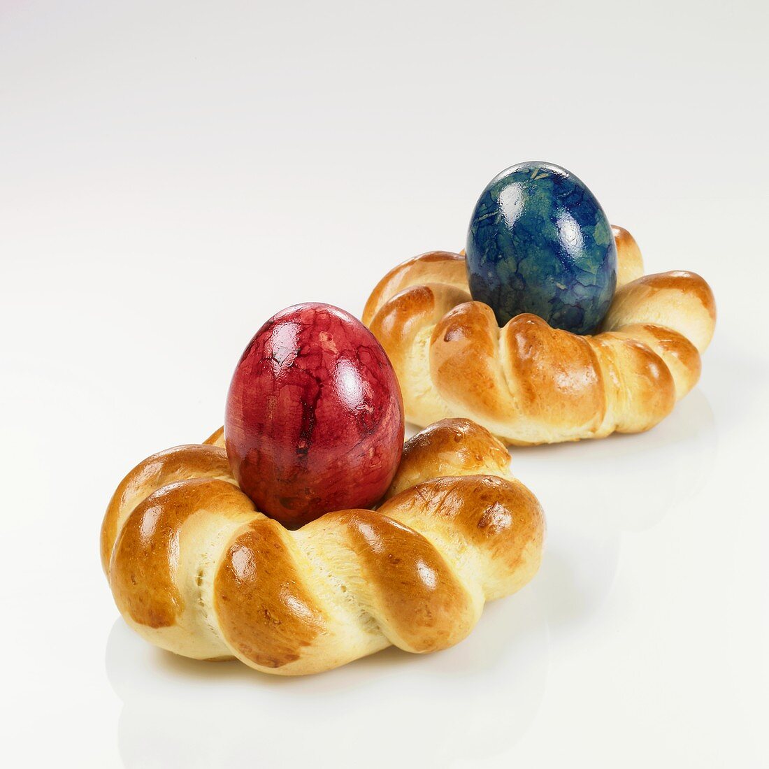 Coloured eggs in two baked Easter nests