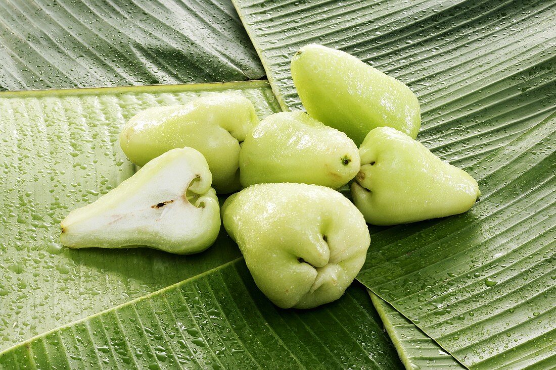 Green Java apples on banana leaves
