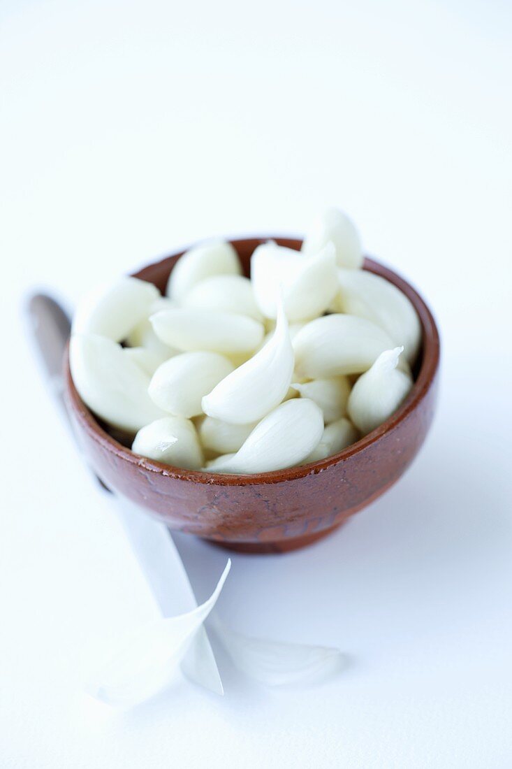 Peeled garlic cloves in a small bowl