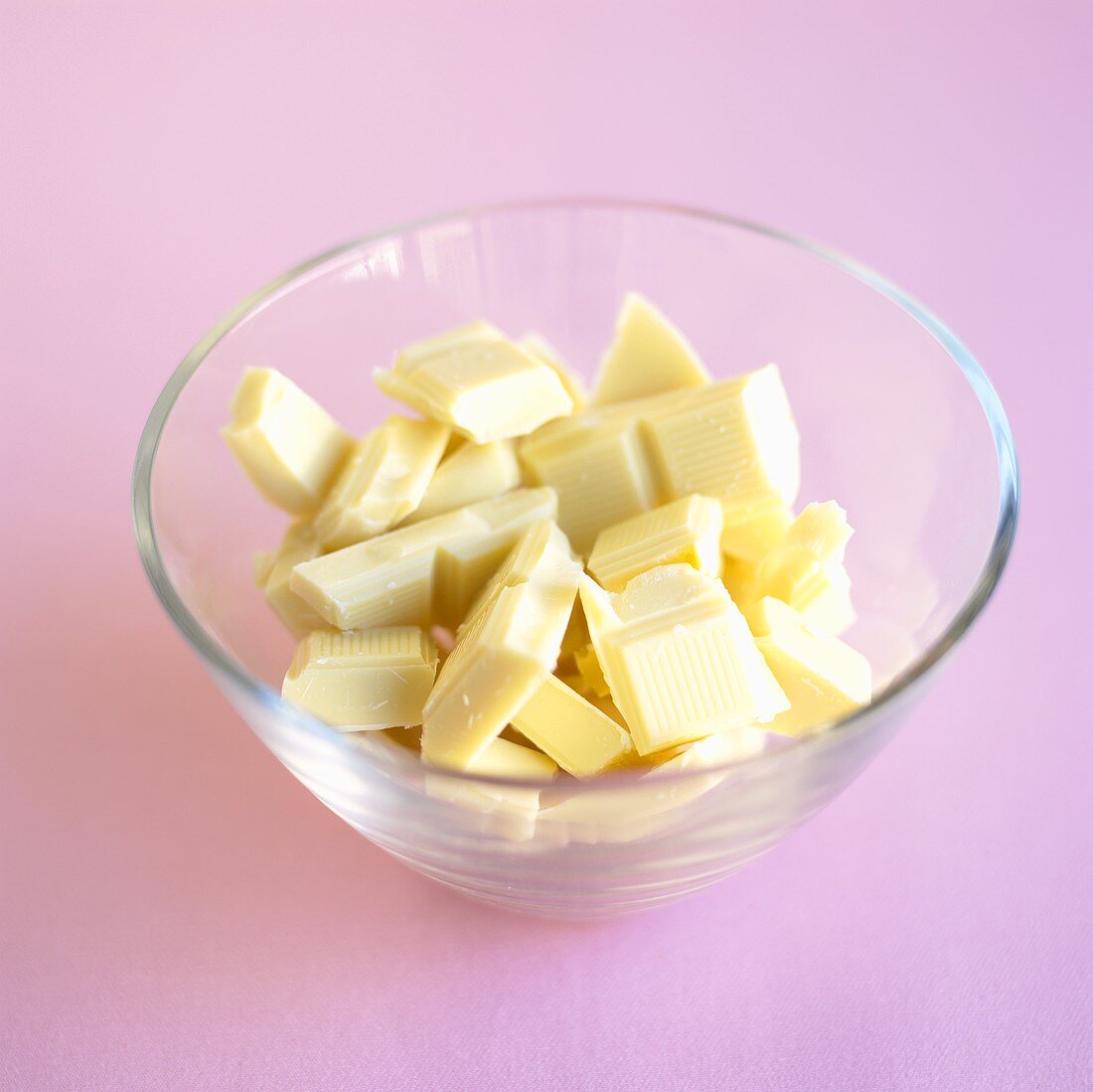 Broken white chocolate in a glass bowl