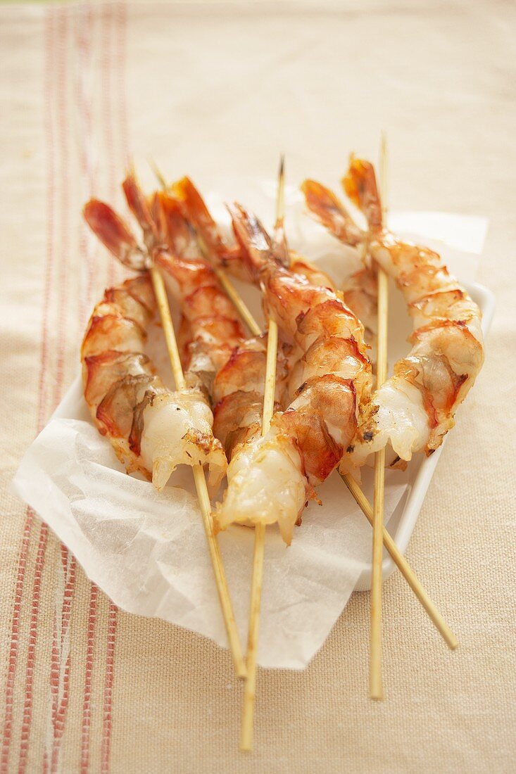 Skewered prawns on greaseproof paper