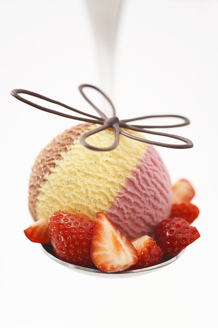 A scoop of Neapolitan ice cream with fresh strawberries