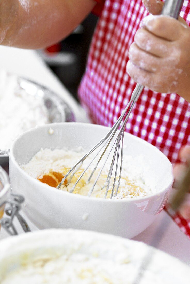 Mixing flour and eggs with a whisk