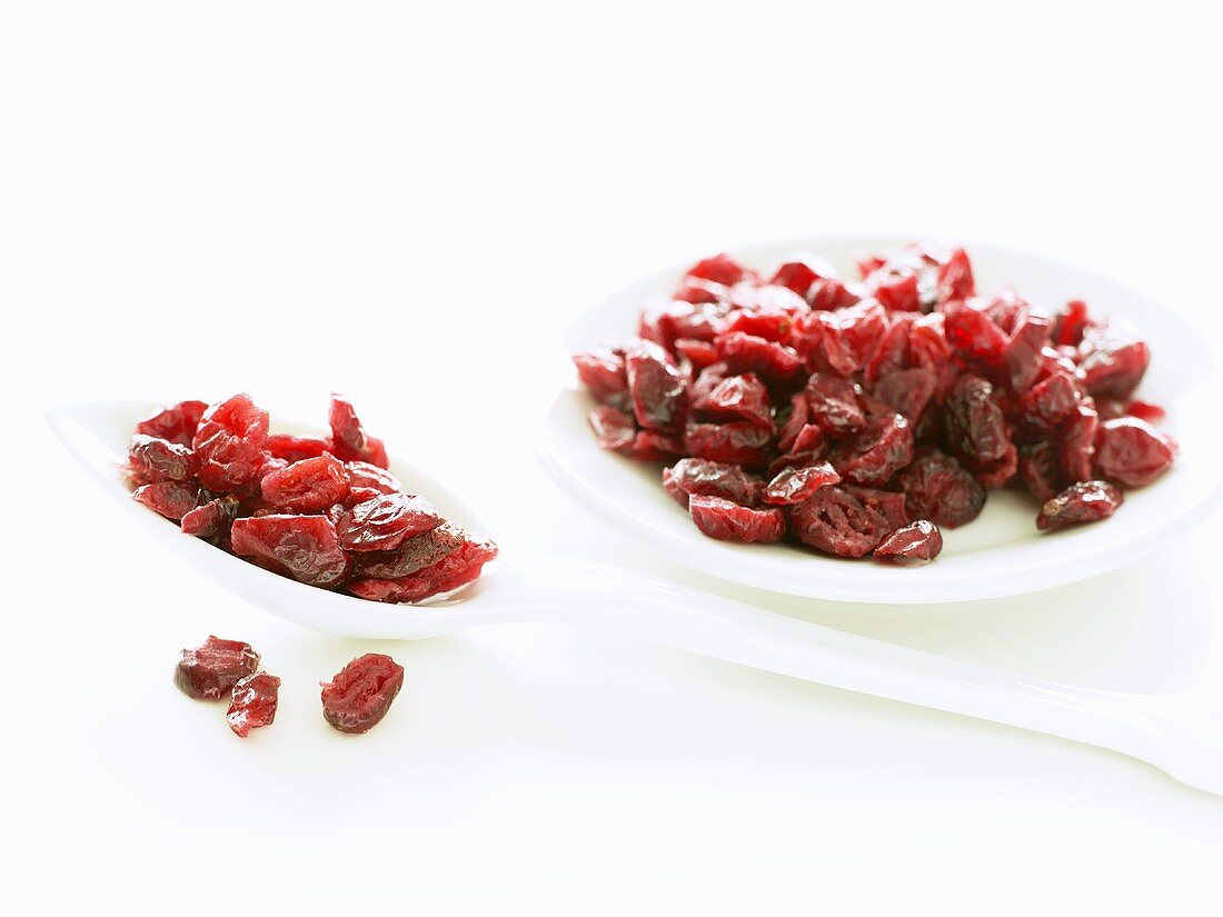 Getrocknete Cranberries auf einem Löffel und Teller