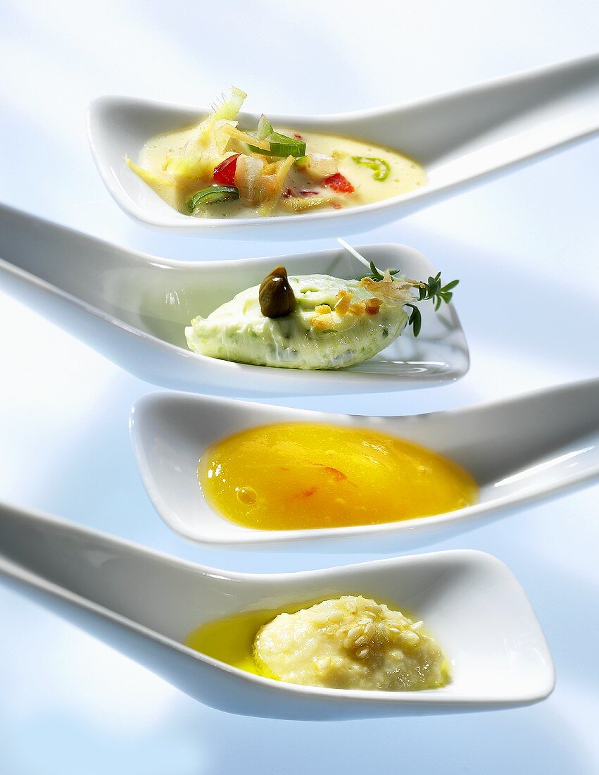 Four sauces and dips on small spoons
