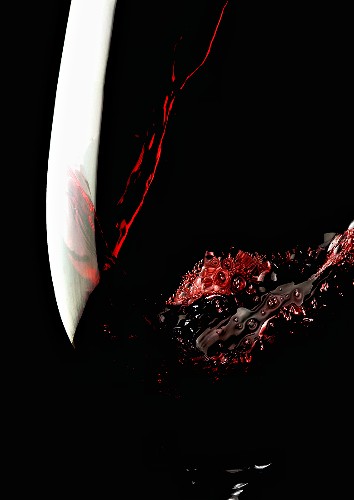 Pouring red wine into glass (close-up)