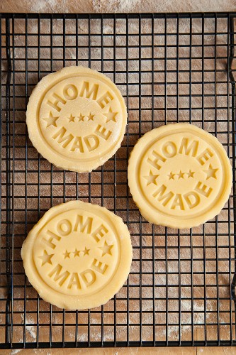 Biscuits stamped with 'home made', on a cooling rack
