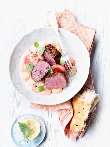 Saddle of lamb with white beans and tomatoes