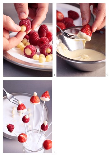 Strawberries and raspberries being dipped in white chocolate