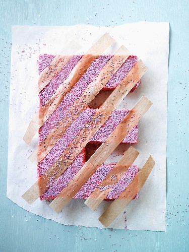 A cake in the shape of an E, with strips of paper