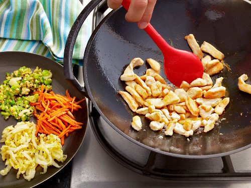 Bami Goreng zubereiten: Hähnchenbrust im Wok anbraten