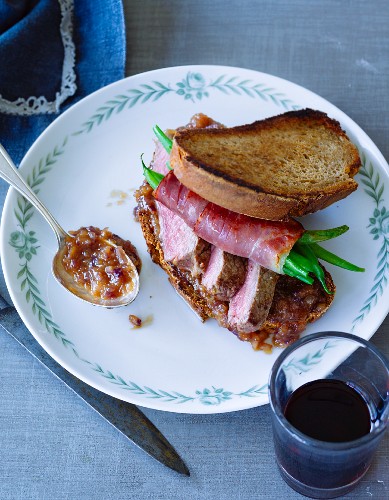 A roast beef sandwich with grilled bread, beans and onion relish