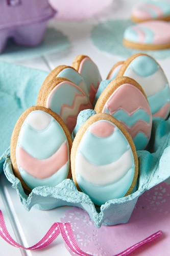 Egg-shaped biscuits with pastel-coloured icing for Easter