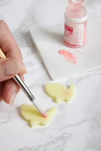 Fondant Easter bunnies being painted with food colouring