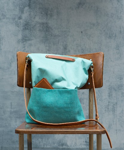 A mint coloured shopping bag with leather straps