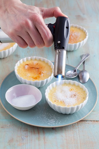 Crème brûlée being caramelised with a Bunsen burner