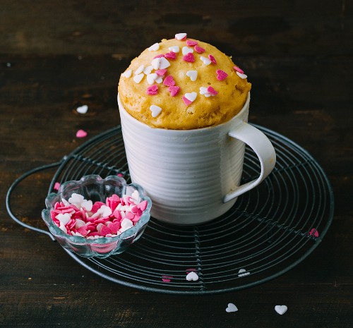 A basic mug cake decorated with sugar hearts