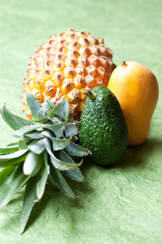 A pineapple, an avocado and a mango