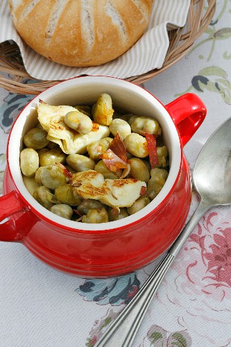 Bean stew with artichoke hearts and bacon strips