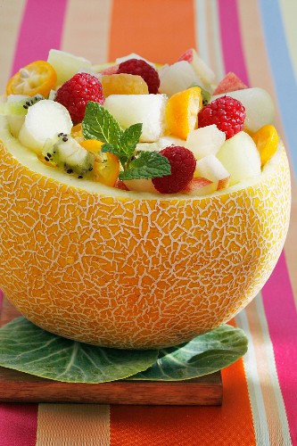 A melon filled with fruit salad
