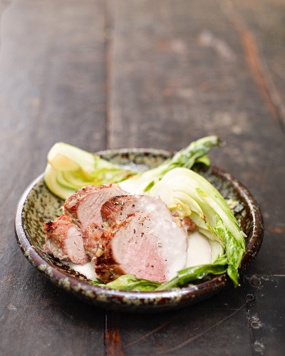 Pork fillets with a ginger and coconut sauce on a bed of bok choy
