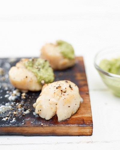 Scallops grilled on a cedar wood plank with avocado pesto
