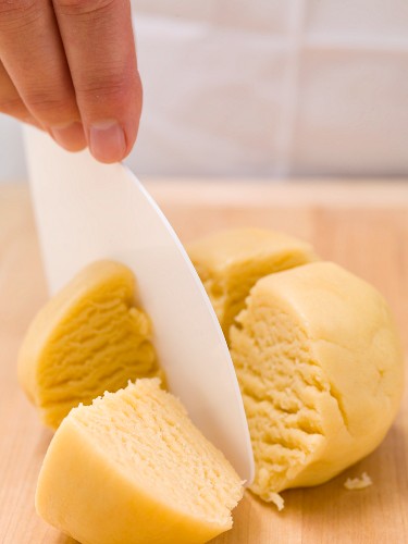 Divide ball of shortcrust pastry into four portions using a dough scraper