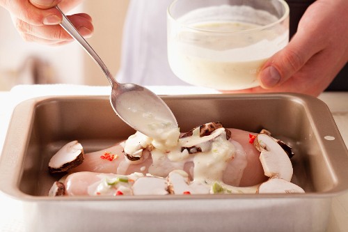 Basting a chicken breast fillet with marinade