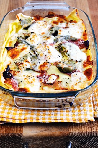 Lasagne with artichokes and ham in a baking dish