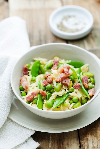 A bowl of orzo pasta with peas, broad beans and bacon
