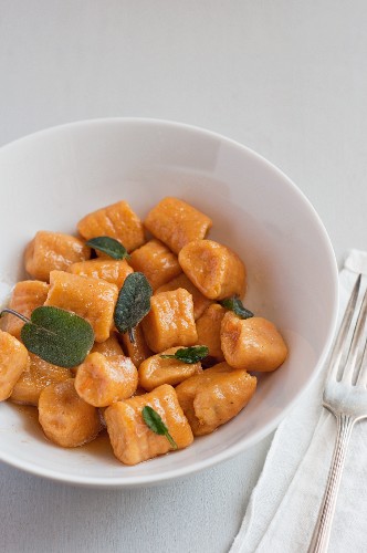 Sweet Potato Gnocchi with Sage Brown Butter Sauce in a White Bowl; Fork and Napkin