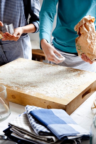 A baking board being dusted with flour
